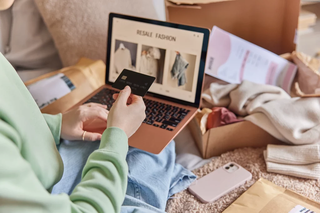 image recadrée d'une femme anonyme tenant une carte de crédit et utilisant un ordinateur portable pour faire des achats