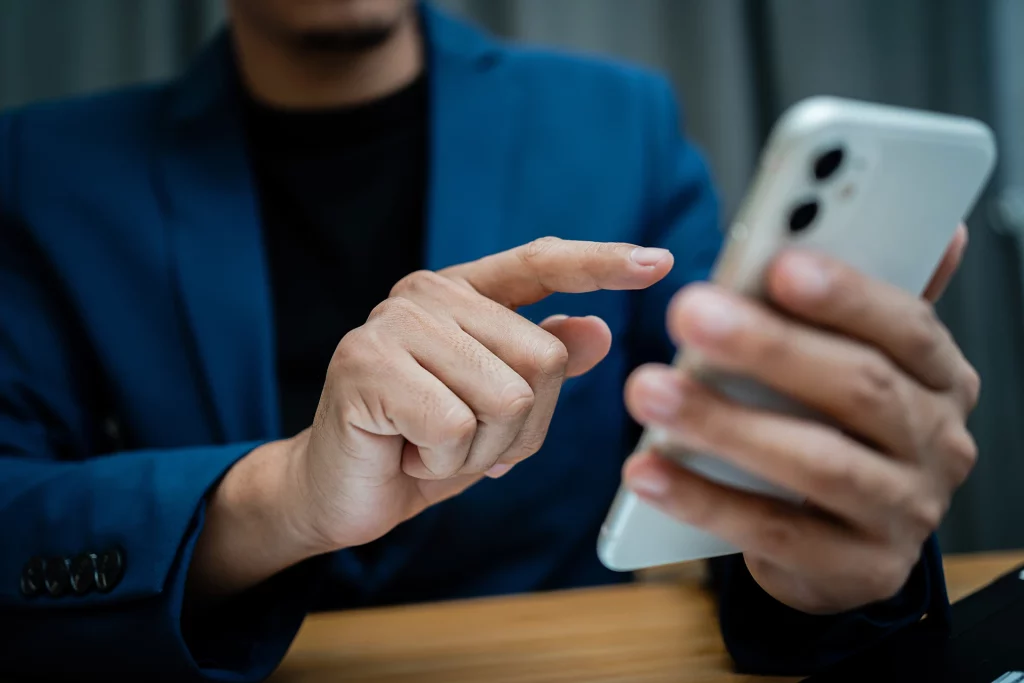 un homme en costume bleu montre son téléphone portable